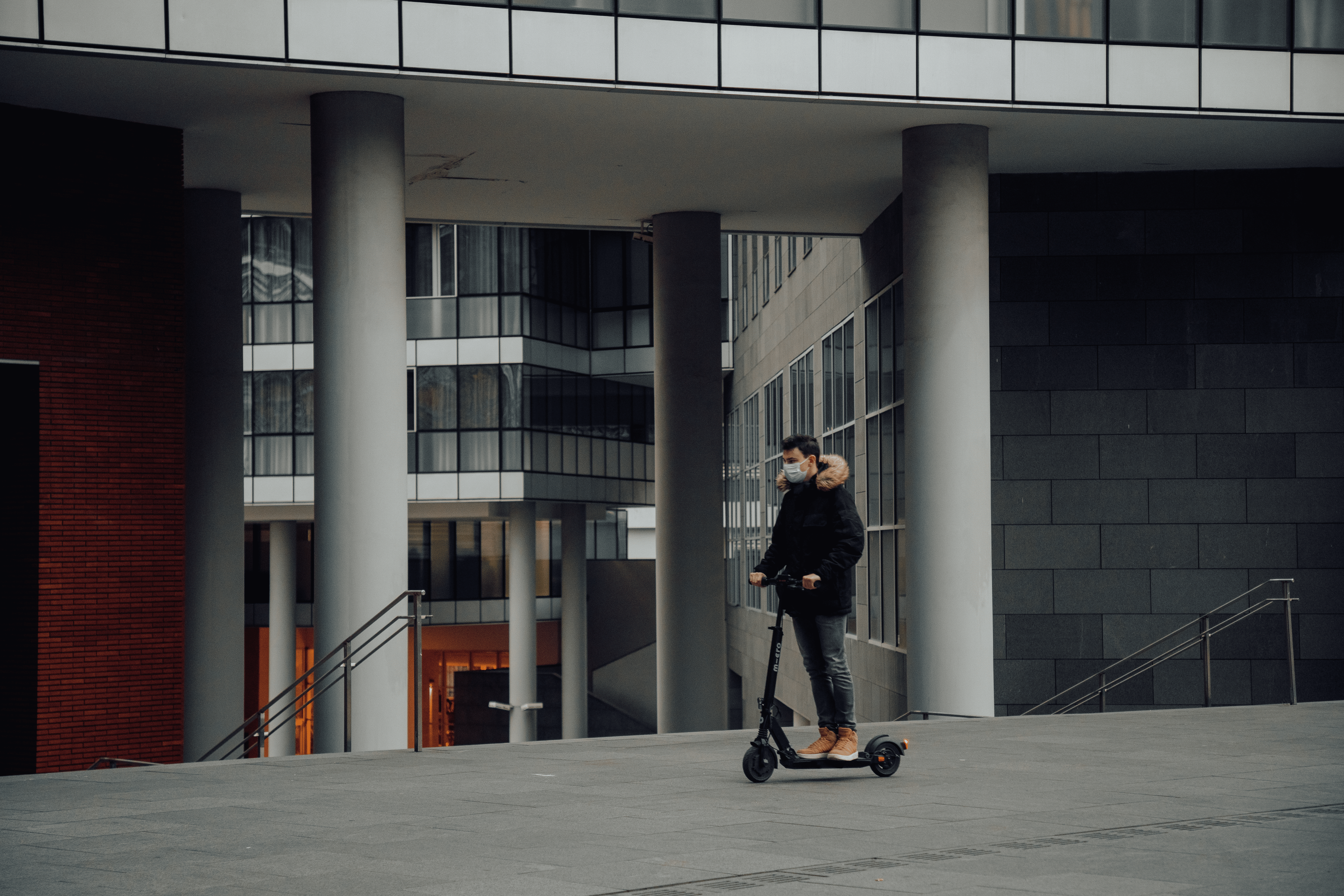 Image homme à trottinette en extérieur avec un masque 