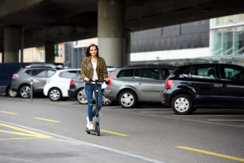 femme qui roule à trottinette sur une piste cyclable